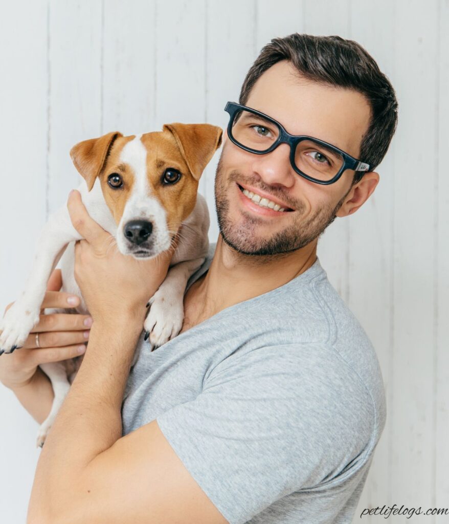 Sam, founder of PetLifeLogs, holding his dog