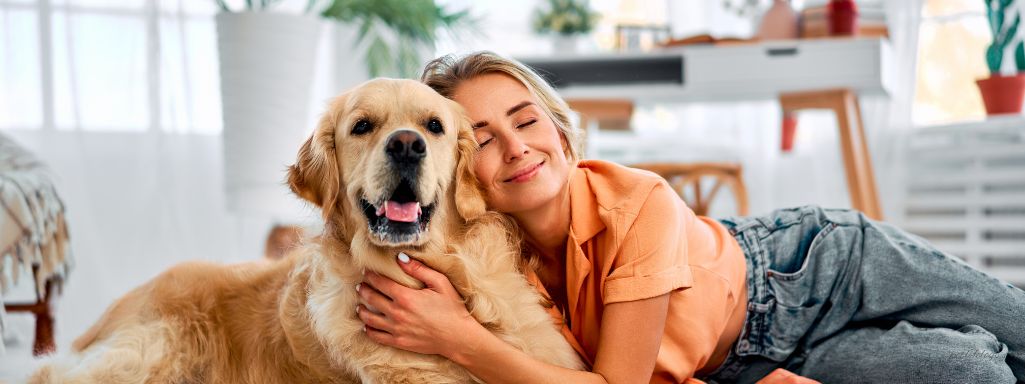 Woman cuddling her golden retriever